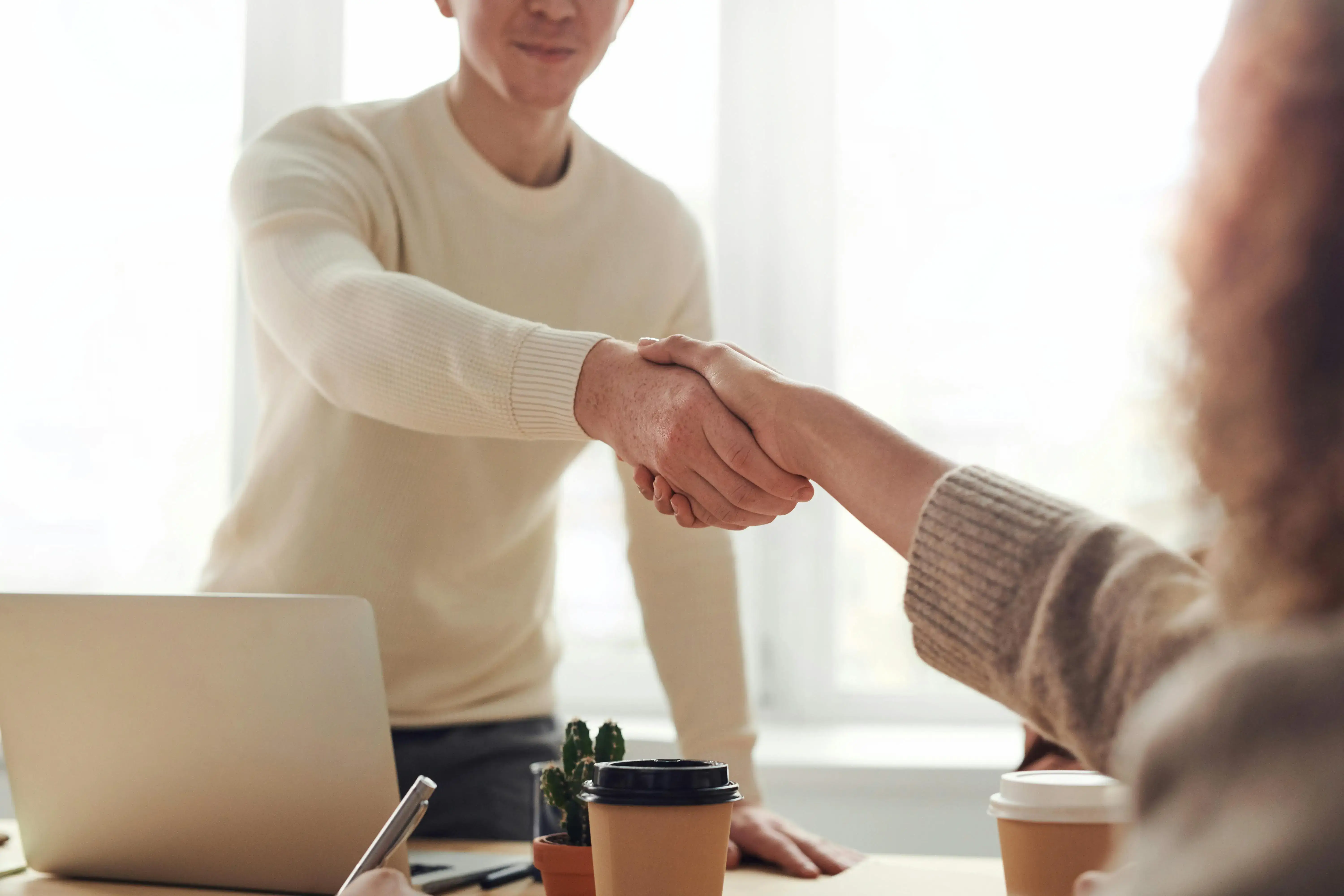 Two people shaking hands over a business agreement